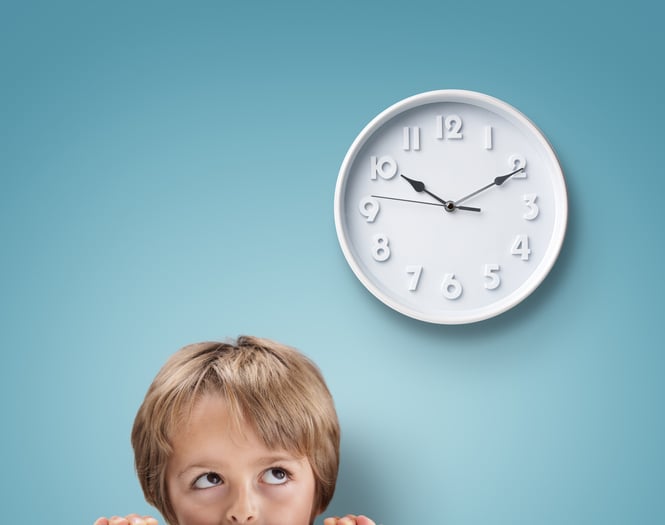 Young boy with autism looking up at a clock
