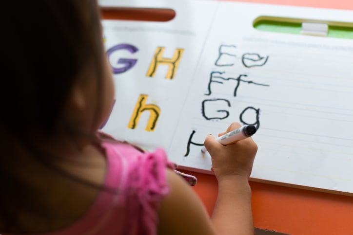 girl with autism practicing writing letters