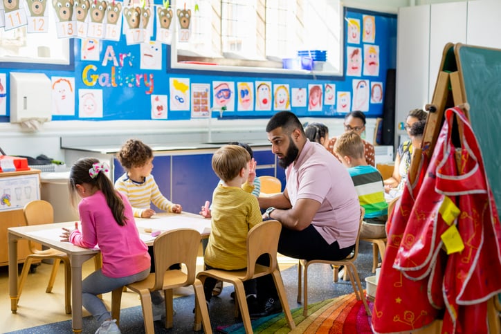 teacher speaking with child with autism in a classroom