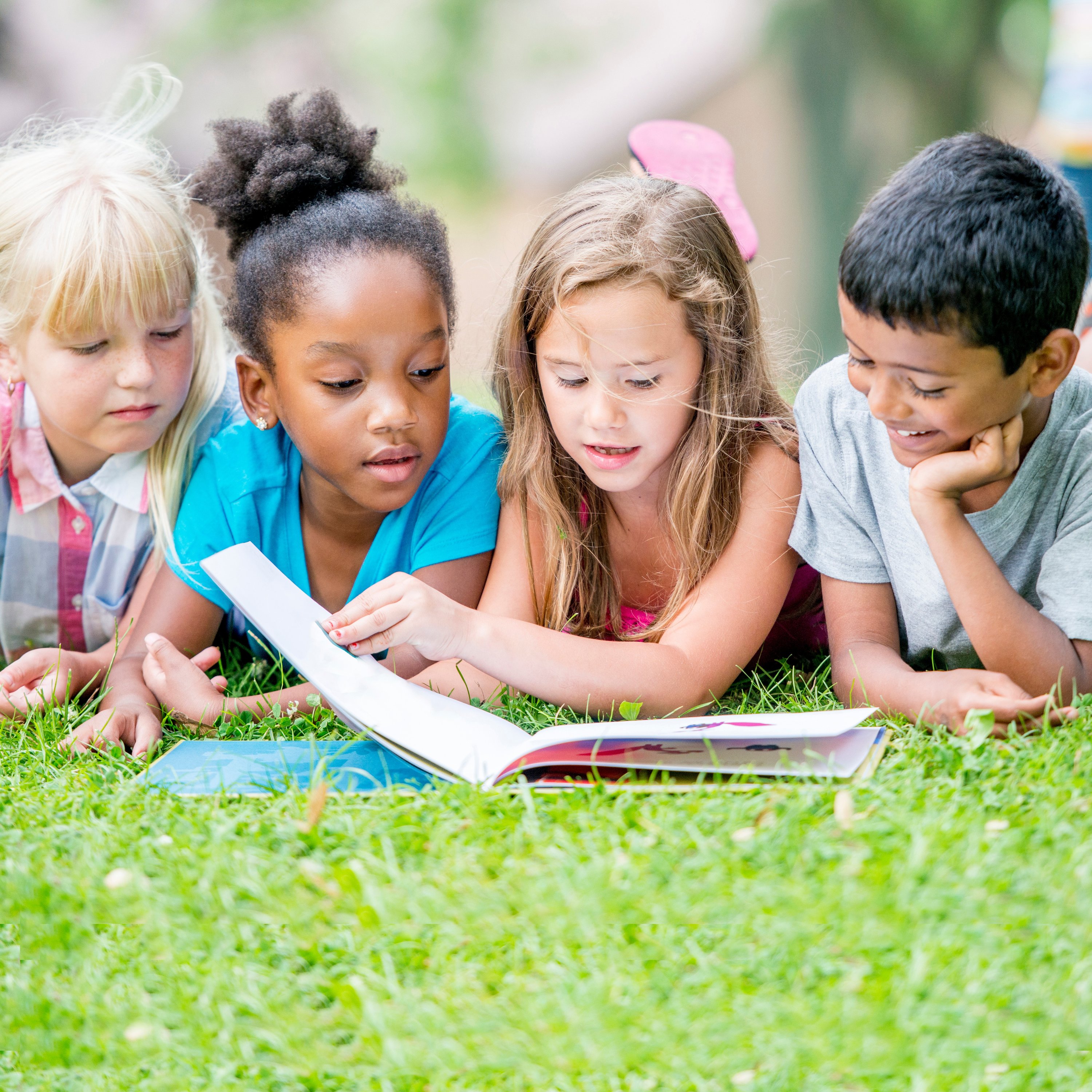 kids reading together in grass