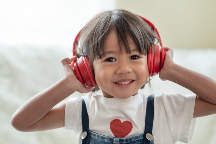 girl with autism wearing noise canceling headphones for sensory